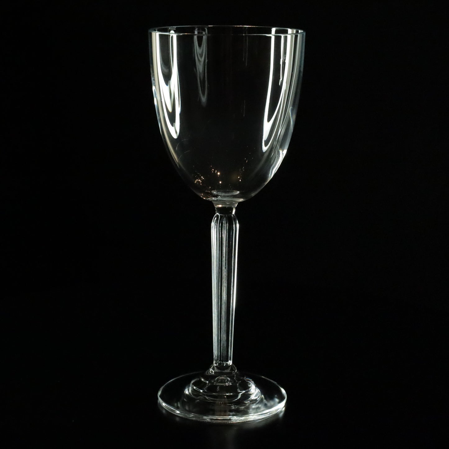 A collection of Aurora white wine glasses with sleek, elongated shapes and clear crystal clarity, arranged symmetrically.