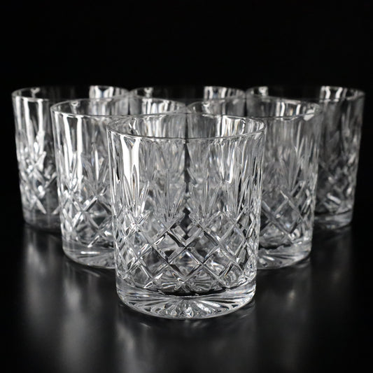 Elegant Crown crystal tumblers featuring intricate diamond-cut patterns, displayed as a complete set of six on a sleek black surface.