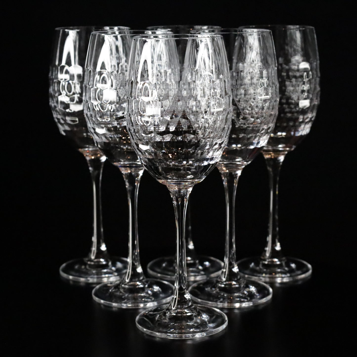 Elegant Lily red wine glasses featuring a textured crystal design and slender stems, displayed in a set of two against a sleek black background.
