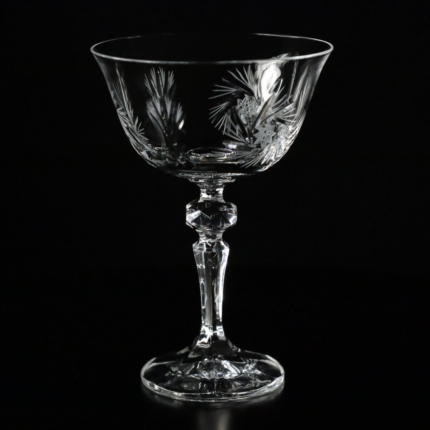 A stunning of Antoinette champagne glass with delicately etched patterns, radiating elegance under soft lighting.