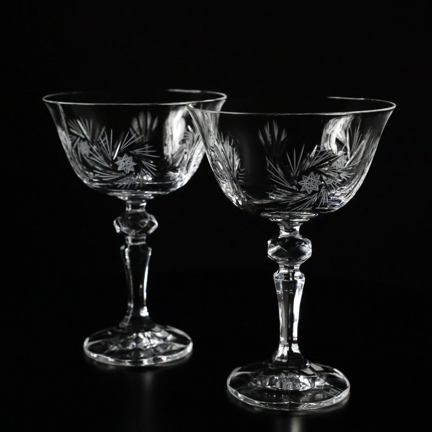 Luxurious Antoinette crystal champagne glasses arranged symmetrically, illuminated against a dark background for a sophisticated look.