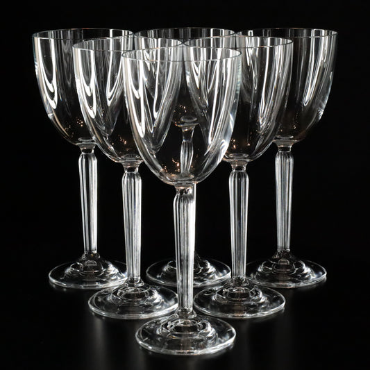 Elegant Aurora white wine glasses with a refined, minimalist design, displayed in a set of six on a sleek black surface.