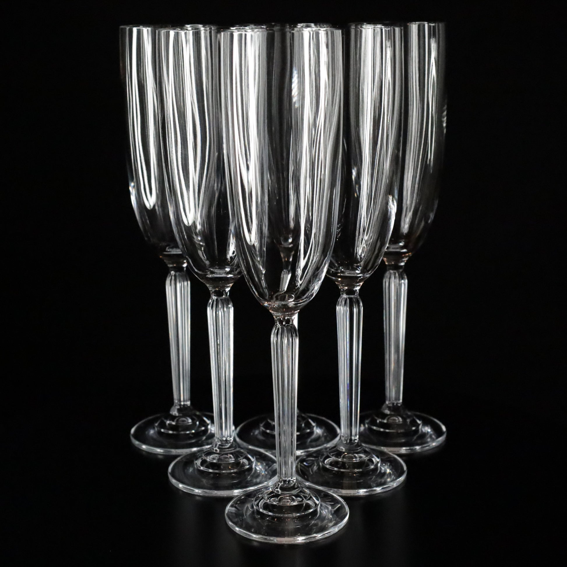 Set of 6 Aurora champagne flutes with a slender stem and clean lines, photographed against a dark, elegant backdrop.