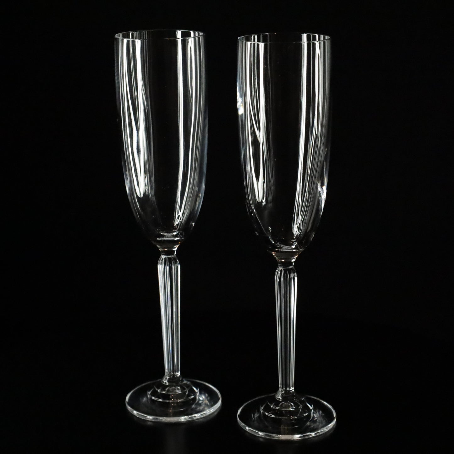 A beautifully crafted Aurora crystal flute, ideal for enjoying champagne, displayed on a sleek black surface.