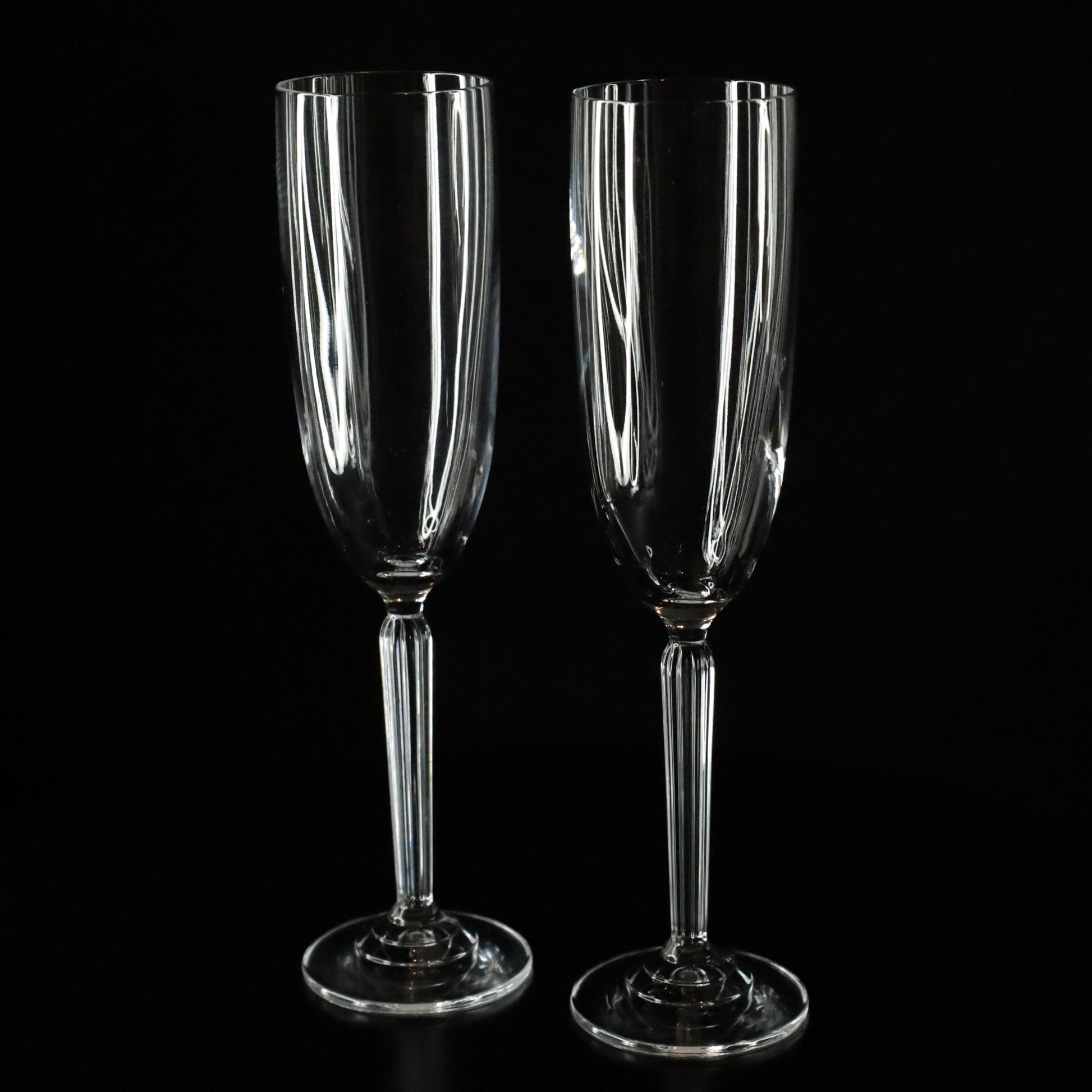 A beautifully crafted Aurora crystal flute, ideal for enjoying champagne, displayed on a sleek black surface.