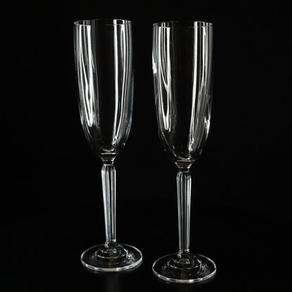 A beautifully crafted Aurora crystal flute, ideal for enjoying champagne, displayed on a sleek black surface.